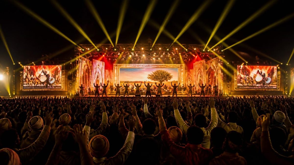 Large Haryanvi live stage show at night with crowd and gold stage lighting — the kind of stage show TKC Talent produces when you book Sapna Choudhary.