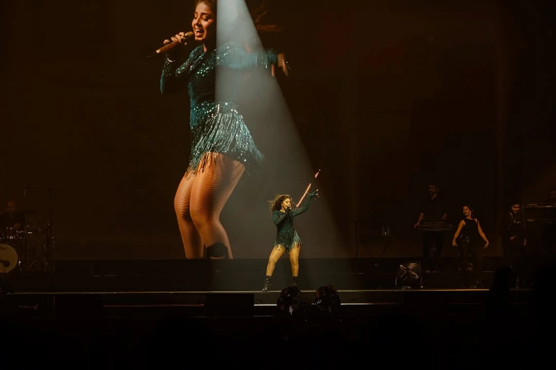 Sunidhi Chauhan singing under spotlight with full concert visuals — TKC Talent